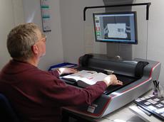 Ein Bibliotheksmitarbeiter scannt Seiten einer wissenschaftlichen Publikation ein. (Bild: ETH-Bibliothek)