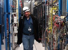 Rainer Wallny schreitet die Serveranlage des CMS-Experiments ab, knapp 100 Meter im Untergrund ETH Life begeleitete ihn auf seiner letzten Schicht. (Bild: Roman Klingler / ETH Zürich)