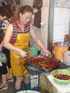 Auf dem Markt bereitet eine Frau Reisaale für den Kunden vor.